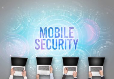 MOBILE GÜVENLİK içgüdü, web güvenliği kavramına sahip bir dizüstü bilgisayarın önünde bir grup insan
