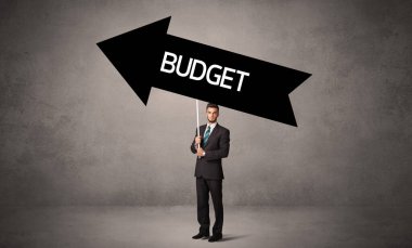 Bütçe yazıtları ve iş yönetimi konseptiyle günlük bekleme yolu tabelasında genç iş adamı