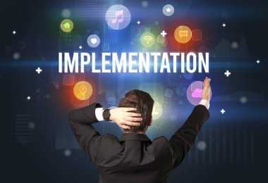 ImpLEMENTATION yazıtları, modern teknoloji konsepti olan bir işadamının arka görüşü