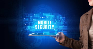 Tablet üzerinde çalışan genç iş adamı dijital işareti gösteriyor: MOBILE GÜVENLİK