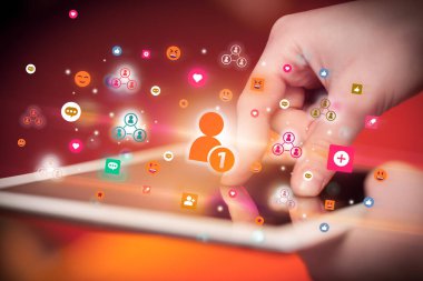 Renkli arkadaş istek simgeleri içeren tablet kullanan bir elin yakın plan görüntüsü, sosyal ağ konsepti