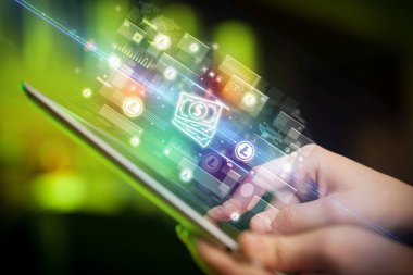 Bir elin, içinden nakit para ikonları çıkan tablet kullanılarak yakın plan fotoğrafı, dijital para birimi kavramı