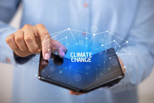 Επιχειρηματίας Κρατώντας Ένα Αναδιπλούμενο Smartphone Επιγραφή Climate Change Έννοια Της — Φωτογραφία Αρχείου