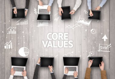 CORE VALUES yazıtları olan bir ofiste çalışan Meşgul İnsanlar Grubu, başarılı iş konsepti