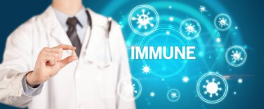 IMMUNE yazıtlı, koronavirüs konseptli ilaç veren doktor.