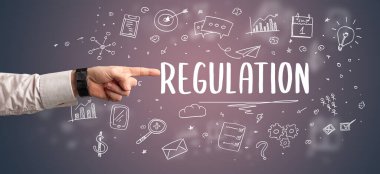 Kesilmiş ellerin yakın çekimi REGULATION yazıtlarına işaret ediyor, modern iş çözümleri kavramı