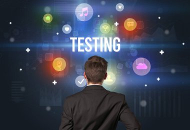 TESTING yazıtları ve modern teknoloji kavramına sahip bir iş adamının arka görünüşü