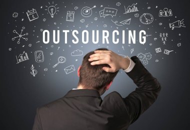 OutTSOURCING yazıtları, modern iş konsepti olan bir iş adamının arka görüşü