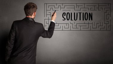 SOLUTION yazıtları ve iş eğitimi konseptiyle labirent çizen işadamı
