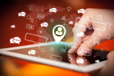 Konum paylaşımı simgeleri içeren tablet kullanan bir elin yakın plan görüntüsü, sosyal medya kavramı