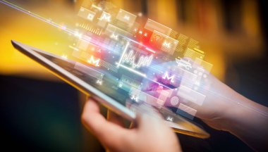 Grafik simgeleri içeren tablet kullanan bir elin yakın plan görüntüsü, dijital para birimi kavramı