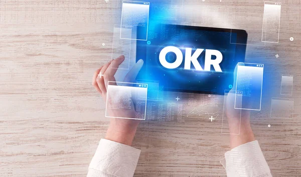 Okrの略語 現代的な技術の概念を持つ手を握っているタブレットのクローズアップ — ストック写真