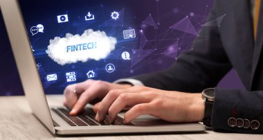 Fintech yazıtları ve modern teknoloji konseptiyle çalışan bir iş adamı.
