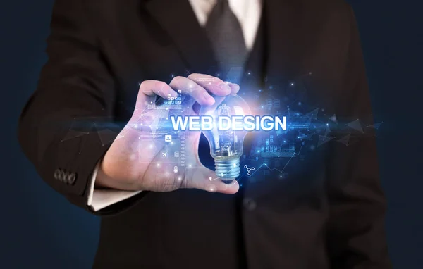 手握灯泡的商人 带有Web设计题字 创新技术概念 — 图库照片