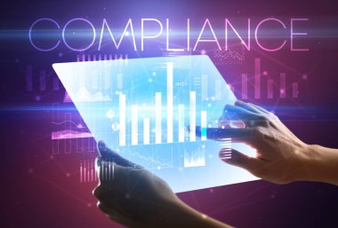 Üzerinde COMPLIANCE yazıtları olan el ele tutuşan fütürist tablet, modern iş konsepti
