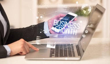 BÜYÜK GROWTH yazıtları ve modern iş konseptiyle birlikte dizüstü bilgisayarda çalışan bir iş adamının yan görüntüsü