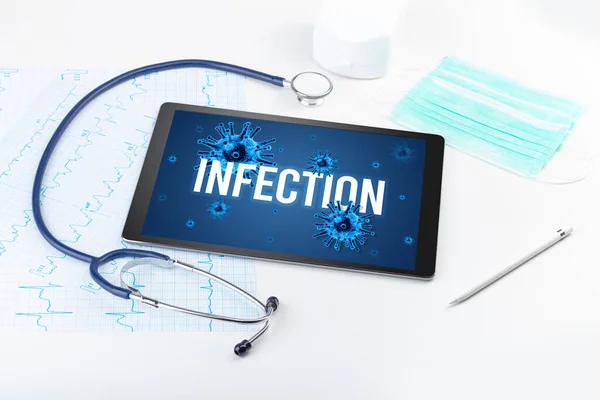 Tablet pc and doctor tools on white surface with INFECTION inscription, pandemic concept