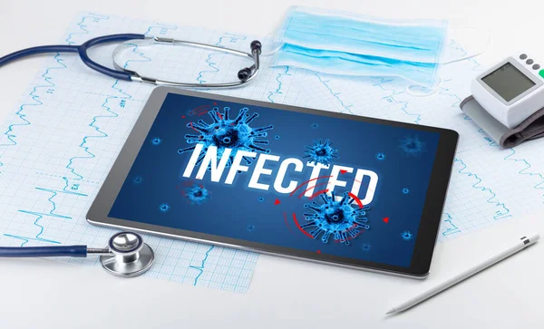 Tablet pc and doctor tools on white surface with INFECTED inscription, pandemic concept