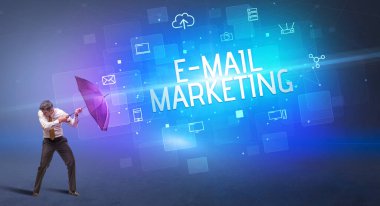 Siber saldırıya karşı şemsiyeyle savunma yapan iş adamı ve e-mail MarkeTING yazısı, çevrimiçi güvenlik kavramı