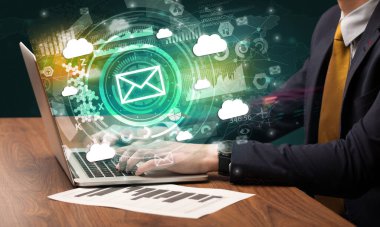 Multimedya ekranından gelen zarf simgesiyle modern bir dizüstü bilgisayarda el yazısı, sezgisel teknoloji kavramı