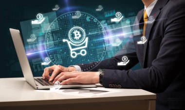 İşadamı, bilgisayar ekranından çıkan bitcoin simgeleriyle birlikte borsada çalışıyor.
