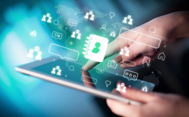 İçinde ajanda simgeleri olan tablet kullanan bir elin kapatılması, sosyal medya kavramı