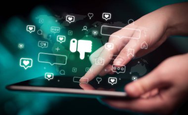Tablet kullanılarak bir elin yakın plan görüntüsü, beğenilmeyen simgeler, sosyal medya kavramı