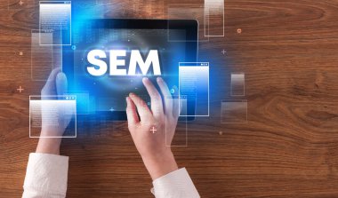 SEM kısaltması, modern teknoloji kavramına sahip el ele tutuşma tabletinin yakın çekimi