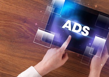 ADS kısaltması, modern teknoloji konsepti olan bir tabletin el ele tutuşması.