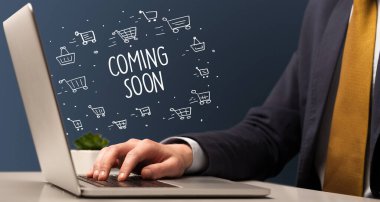 İş adamı dizüstü bilgisayarda Coming Soon yazıtı ve online alışveriş konseptiyle çalışıyor.