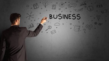 İş adamı, BUSINESS yazıtları ve iş stratejisi konseptiyle yaratıcı bir fikir çizimi yapıyor.