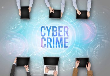 CYBER CRIME insciption, web güvenlik kavramı olan bir dizüstü bilgisayarın önünde bir grup insan