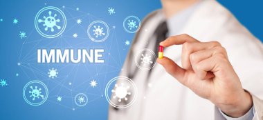 IMMUNE yazıtlı, koronavirüs konseptli ilaç veren doktor.