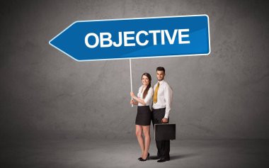 OBJECTIVE yazıtları, yeni iş yönü kavramı ile günlük bekleme yolu tabelasında genç iş adamı