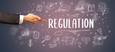 Kesilmiş ellerin yakın çekimi REGULATION yazıtlarına işaret ediyor, modern iş çözümleri kavramı