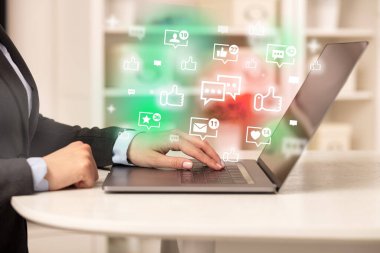 Sohbet simgeleriyle dizüstü bilgisayarda sörf yapan genç kişi, sosyal medya kavramı