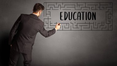 EDUCATION yazıtları ve iş eğitimi konseptiyle labirent çizen işadamı
