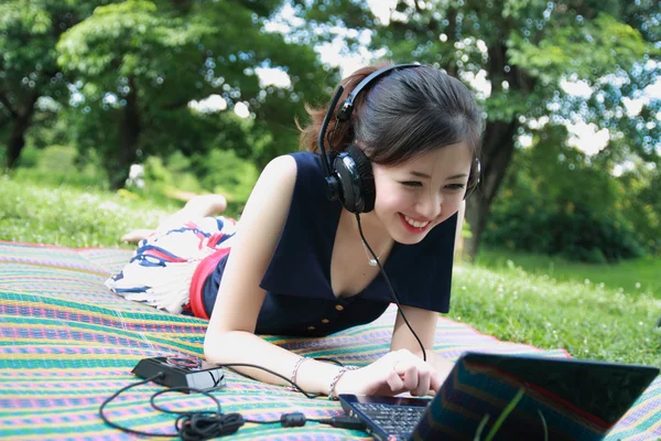 Vacker tonåring lyssnar musik på laptop. — Stockfoto