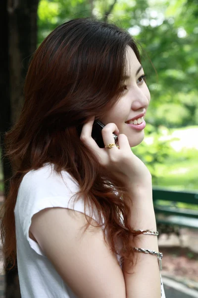 Mujer disfrutando del aire libre mientras habla en un teléfono celular —  Fotos de Stock