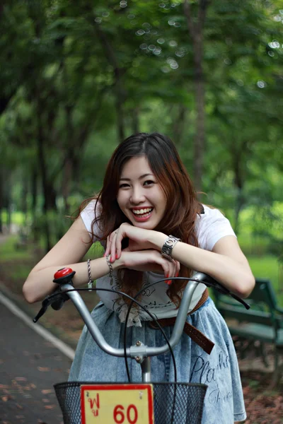 Femme avec un vélo à l'extérieur souriant — Photo