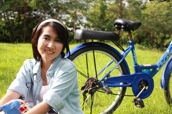 Kvinna med en cykel utomhus leende — Stockfoto