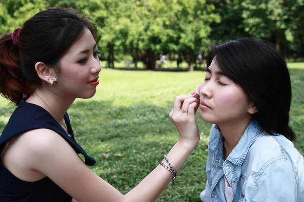 Beautiful girls helping their friend to makeup — Stock Photo, Image
