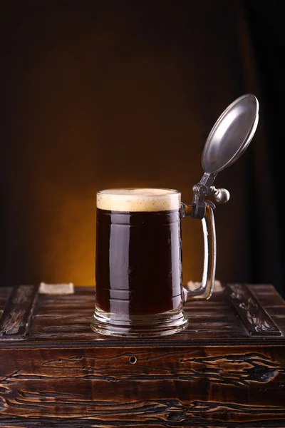 Mug of dark beer on a chest — Stock Photo, Image