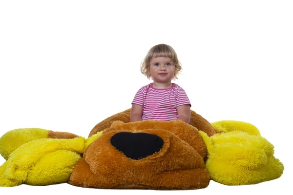 A child sits on a soft toy on a white background — Stock Photo, Image