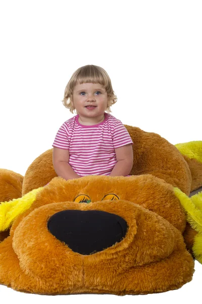 A child sits on a soft toy on a white background — Stock Photo, Image