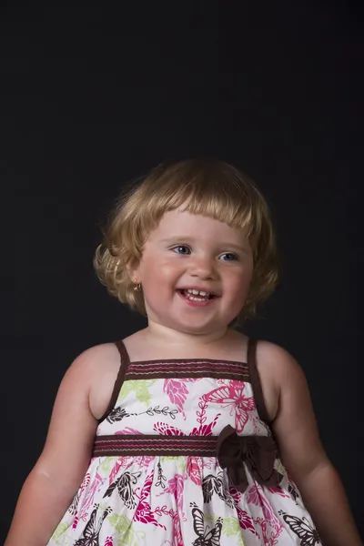 Belo sorriso de uma menina em um fundo preto — Fotografia de Stock