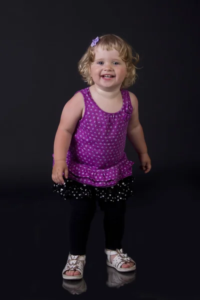 Belo sorriso de uma menina em um fundo preto — Fotografia de Stock