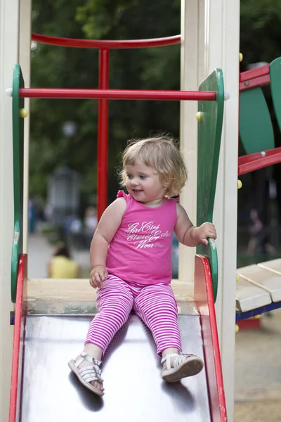 Очаровательная маленькая девочка развлекается на детской площадке — стоковое фото