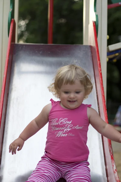 Adorable petite fille qui s'amuse sur une aire de jeux — Photo