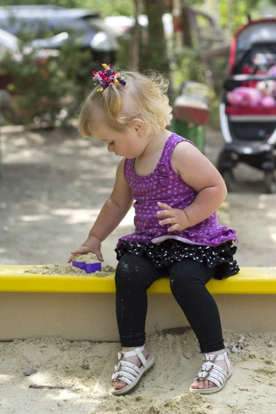 Чарівна маленька дівчинка розважається на дитячому майданчику — стокове фото